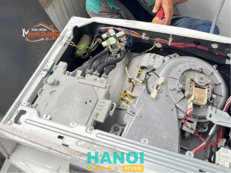 Kỹ thuật viên Sửa Chữa Minh Dương đang đo kiểm bo mạch máy giặt tại nhà khách hàng ở Hà Nội.